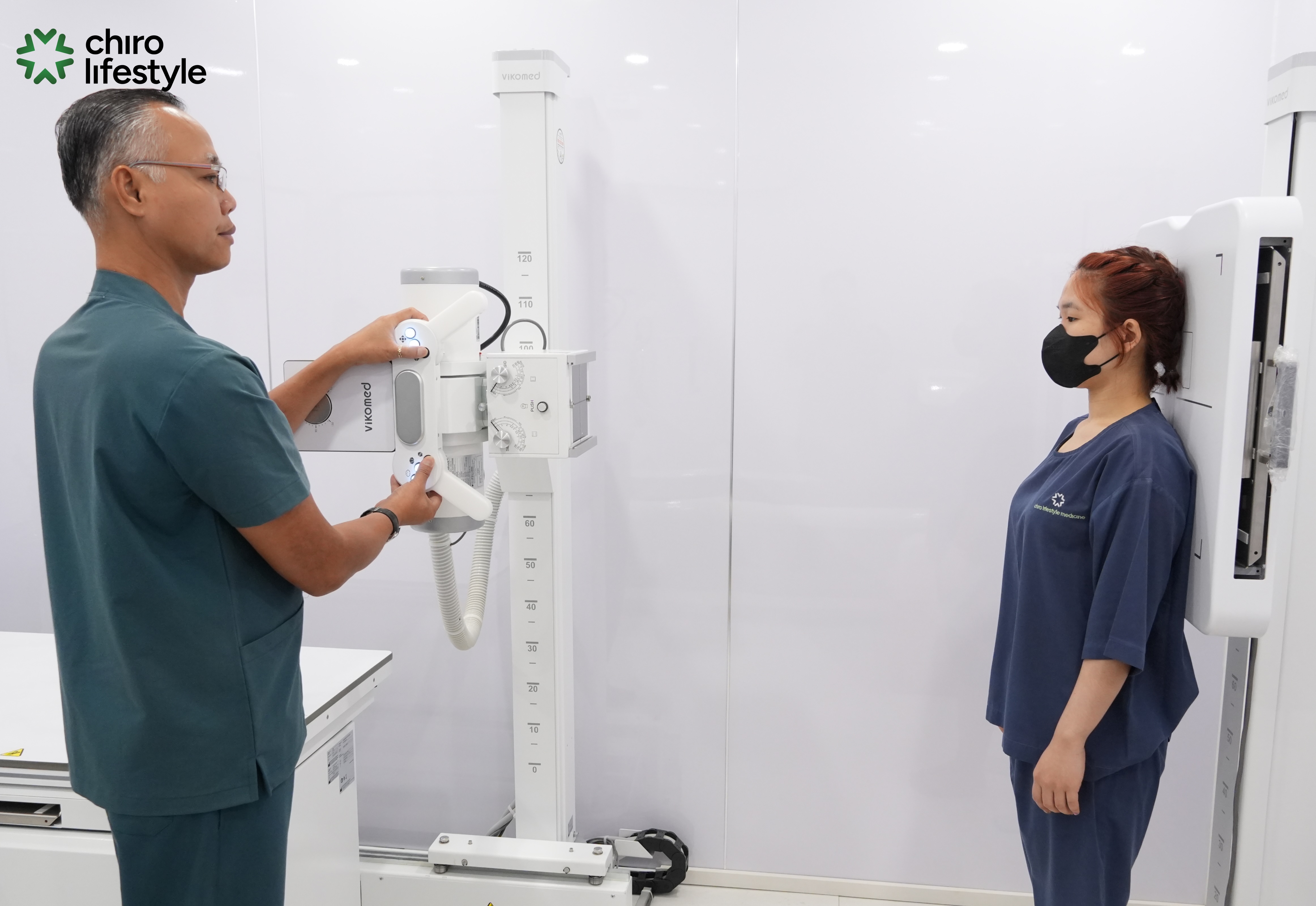 A radiologic technologist operates the modern digital X-ray system.